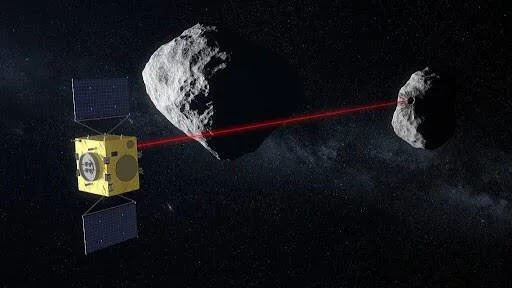 Ilustración de una nave espacial amarilla disparando un rayo láser rojo entre dos asteroides en el espacio.