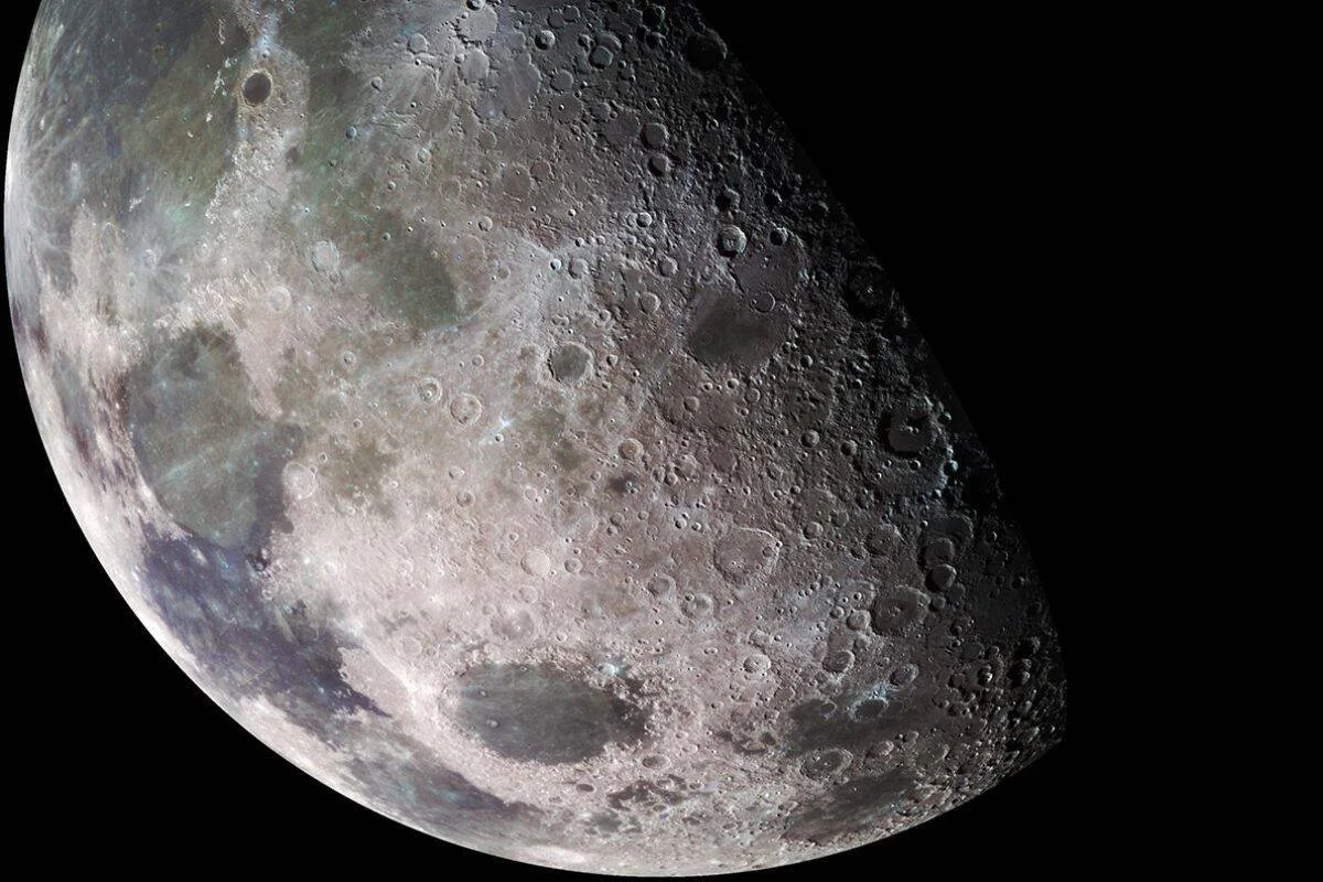 Vista de cerca de la superficie de la Luna mostrando numerosos cráteres y mares lunares sobre fondo negro del espacio.
