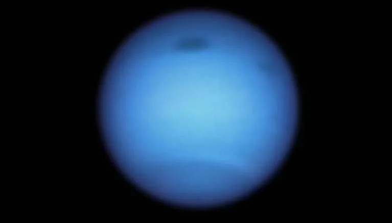 Neptuno fotografiado desde el espacio, mostrando su característica coloración azul intensa sobre fondo negro.