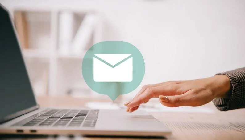 Mano señalando una laptop con un ícono de correo electrónico superpuesto, representando el envío o gestión de emails.
