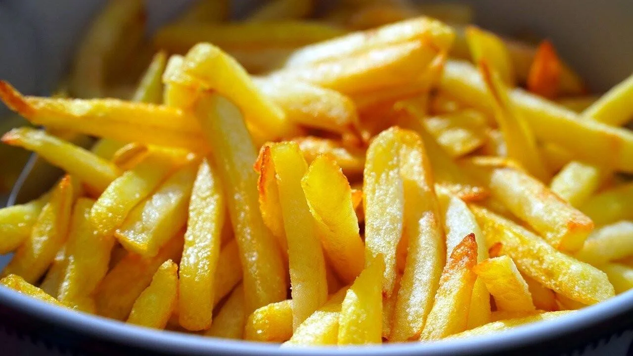Abundante porción de papas fritas doradas y crujientes servidas en un tazón.