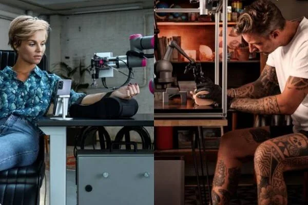 Un brazo robótico tatúa a una mujer mientras un tatuador cubierto de tatuajes opera el sistema a distancia.