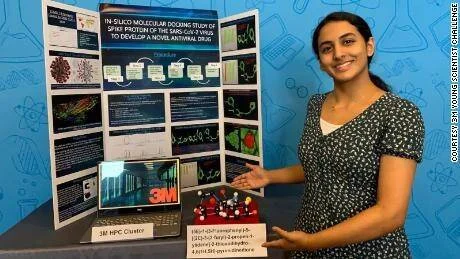 Estudiante adolescente sonríe junto a su proyecto de feria científica sobre acoplamiento molecular de la proteína spike del SARS-CoV-2.