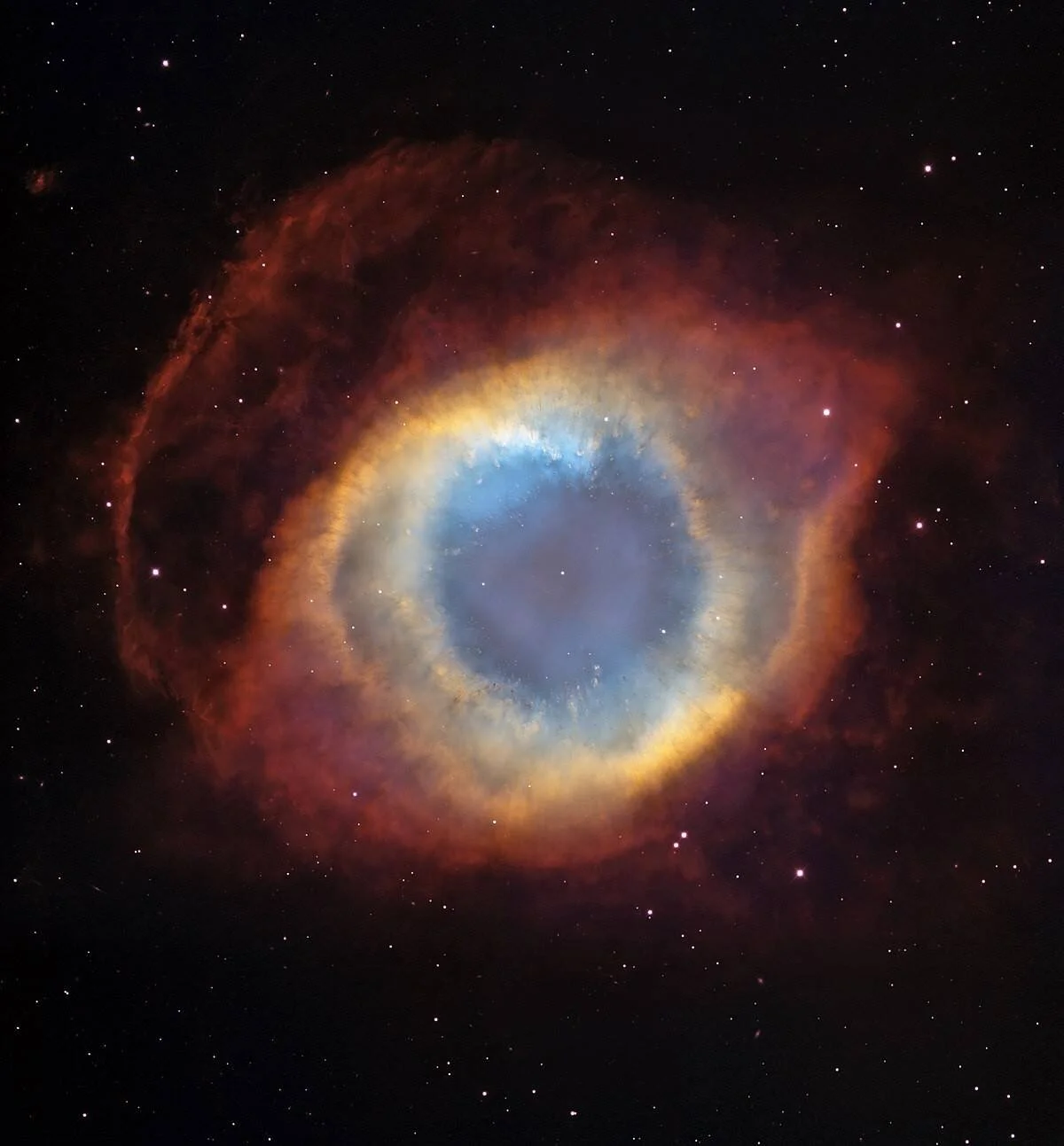 Nebulosa planetaria con forma de ojo: anillos concéntricos rojizos y dorados rodean un interior azul celeste sobre fondo estrellado.