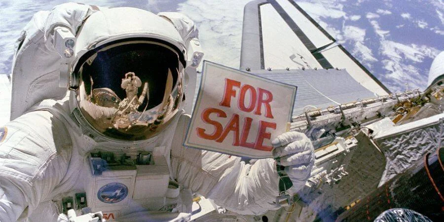 Astronauta de la NASA en caminata espacial sosteniendo un cartel que dice 'For Sale', con la Tierra de fondo.